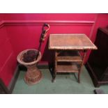 A bamboo table with a wicker umbrella stand and two carved African items