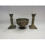 A white metal Japanese bowl decorated with dragons together with a pair of candlesticks, also with