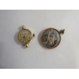 A 9ct gold lady's watch face and a yellow metal surround pendant