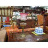 A Victorian oil lamp with cut glass reservoir and etched cranberry glass shade