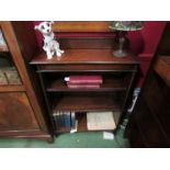 An Edwardian oak bookshelf with height adjustable shelves and beaded decoration on an arched end