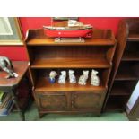 A Bevan Funnell Georgian style flame mahogany waterfall bookshelf over a two door cupboard with