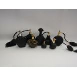 Nine black coloured scent bottles/atomisers including ribbed body and gilt decorated examples