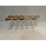 Eleven decorative wine glasses with gilt decorated rim, some rubbing to gilt