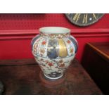 An Imari vase on wooden Chinese stand, 22cm tall