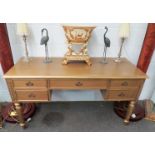 A gold dressing table on fluted column legs, two drawers either side, one central, 145 x 61 x 76cm