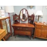 An Arts & Crafts walnut dressing chest in the manner of William Birch, the oval tilt mirror on
