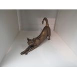 A bronze effect figure of a stretching cat