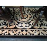 A large Chinese black and gold rug, 244cm x 153cm