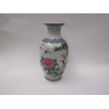 An Oriental porcelain vase with handpainted cranes, blossom and trees, with written script to the