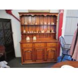 An oak Welsh dresser base and rack, three drawers over three doors, 186cm x 140cm x 46cm