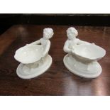 A pair of white Royal Worcester salt dishes in the form of mermaids holding a shell, 10cm x 14cm