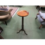 A circa 1900 and later oak candle stand the circular dished top on a turned column and tripod