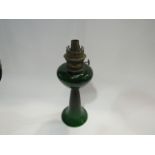 An early 20th Century oil lamp, dark green glass with wrythen trumpet form base. No shade. 35cm high