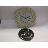 A Howdens Joinery iron pot stand together with a Roger Lascelles tin clock "La Poissonnerie" No.