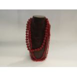 A necklace of cinnabar type beads, faux coral necklace and red glass bugle bead necklace (3)