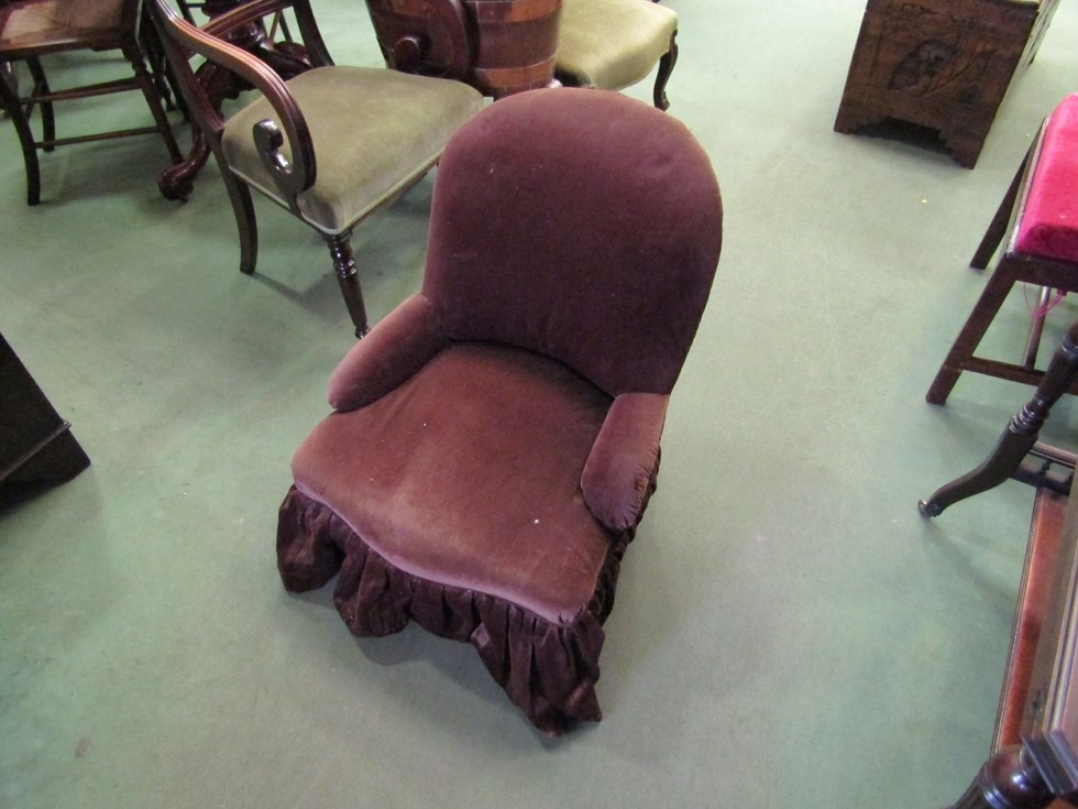 A chocolate brown upholstered bedroom chair on turned legs