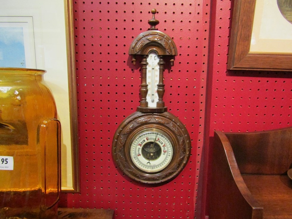 An Edwardian heavily carved barometer with mercury thermometer