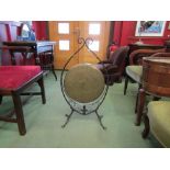 A brass gong on ornate wrought iron stand, no beater