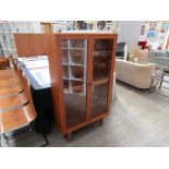 A Danish teak glazed two door cabinet with teak and glass shelved interior, raised on tapering legs.