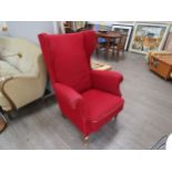 A 1940's Danish high backed winged armchair with original deep red upholstery, raised on dark