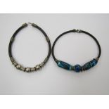 Two 1970's chunky leather thong necklaces one with large turquoise pottery beads and one stainless