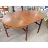 A teak extending dining table in the Danish style, D-ends and raised on slender angled legs.