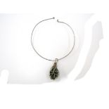 A large caged aventurine nugget stone on a silver torc necklace.