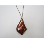 A large flame Jasper stone pendant set in hallmarked silver and hung on a silver chain