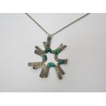 A Mid 20th Century 'splash' form white metal pendant with Peacock eye foil glass stones hung on a