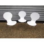 Three Habitat stacking chairs in white painted ply and chromed legs.