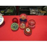 Six glass paperweights of various designs