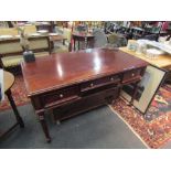 A Victorian style writing table of three faux and three frieze drawers on turned and carved legs.