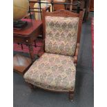 An oak framed button back low chair on castors, upholstered in tapestry style fabric