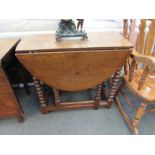 An 18th Century pegged oak gate-leg table, the oval top and cutlery end drawer over bobbin turned