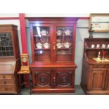 An Arts & Crafts walnut bookcase on base, the two glazed doors with working lock and key over a
