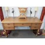 A gilt dressing table on fluted column legs, two drawers either side, one central, 145cm x 61cm x