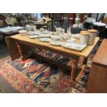 A Victorian style natural pine refectory table on cannon barrel legs joined by an 'H' stretcher.