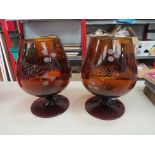 A pair of oversized amber cut glass brandy balloons, 24cm tall