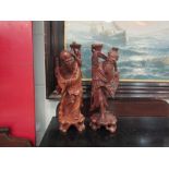 A pair of Oriental carved hardwood fisherman form table lamps (part converted)