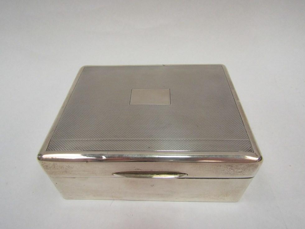 A silver cigarette box, vacant cartouche and engine turned, marks rubbed