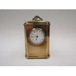 A brass carriage clock with Arabic chapter ring. Raised on ball feet
