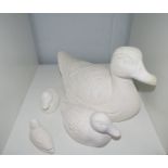 A plaster duck and three ducklings of varying sizes, largest 32cm long, smallest 9cm