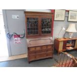 An Edwardian oak bookcase bureau, the lead glazed two doors and height adjustable shelves over a