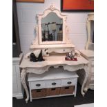 An ornate cream reproduction dressing table with scroll foliate legs, bevel edged mirror with two