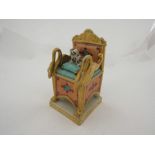 A 19th Century porcelain inkwell and quill holder in the form of a throne chair, with dog seated