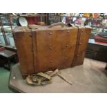 An early 20th Century brown leather suitcase/trunk of large proportions with carrying handle and