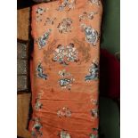 An early 20th Century Chinese coral silk textile hand embroidered in blue dragons and flowers,