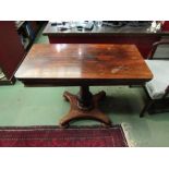 A 19th Century rosewood tea table, the round cornered fold-over top upon a plain and carved tapering