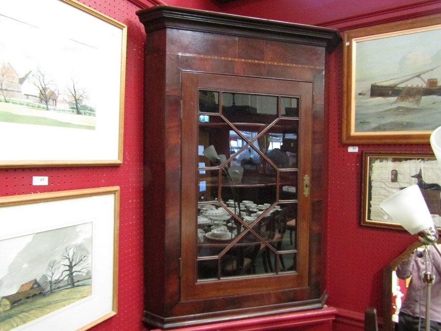 A Georgian flame mahogany corner cabinet with glazed door and shaped shelved interior with key, 86cm